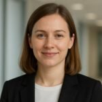 Portrait d'une femme souriante en blazer noir.